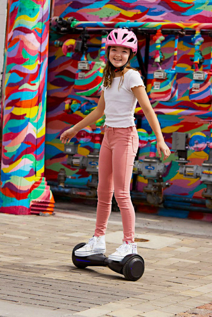 Young girl joyfully riding a hoverboard