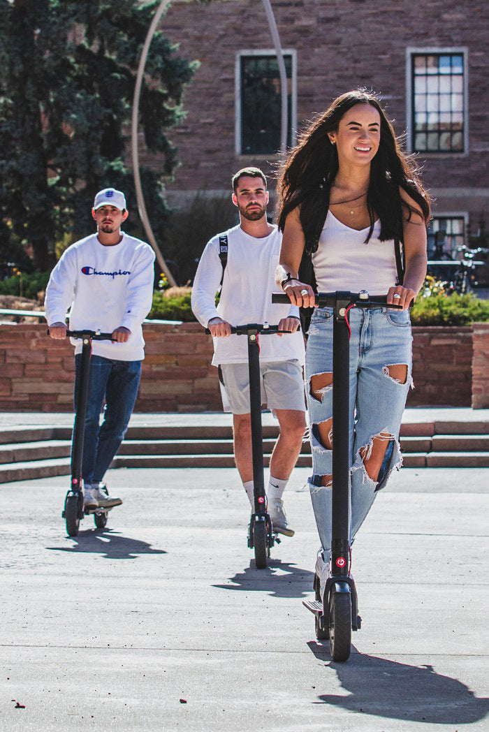 College student riding an e-scooter on campus